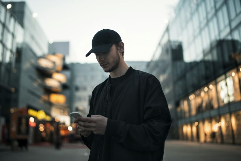 Eine Person in der Stadt schaut aufs Handy