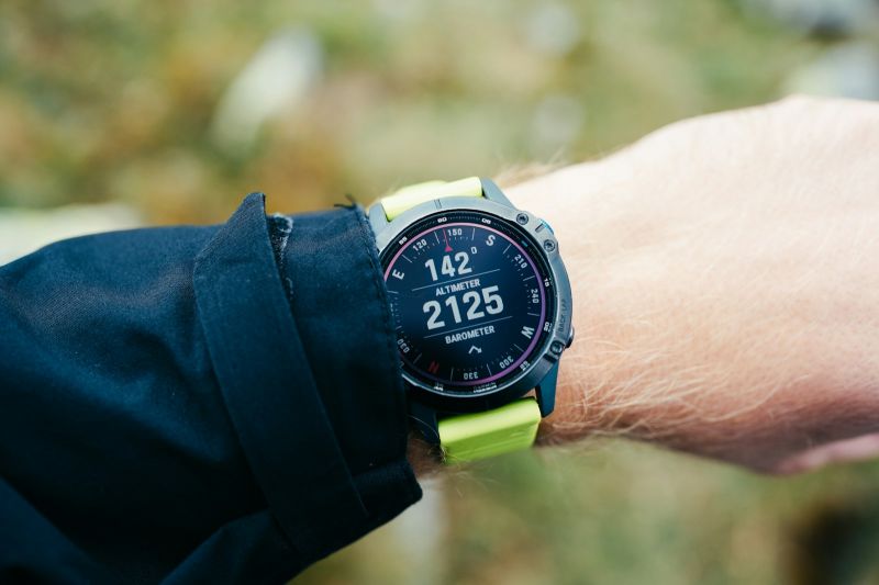 Une montre Garmin à bracelet jaune-vert au poignet